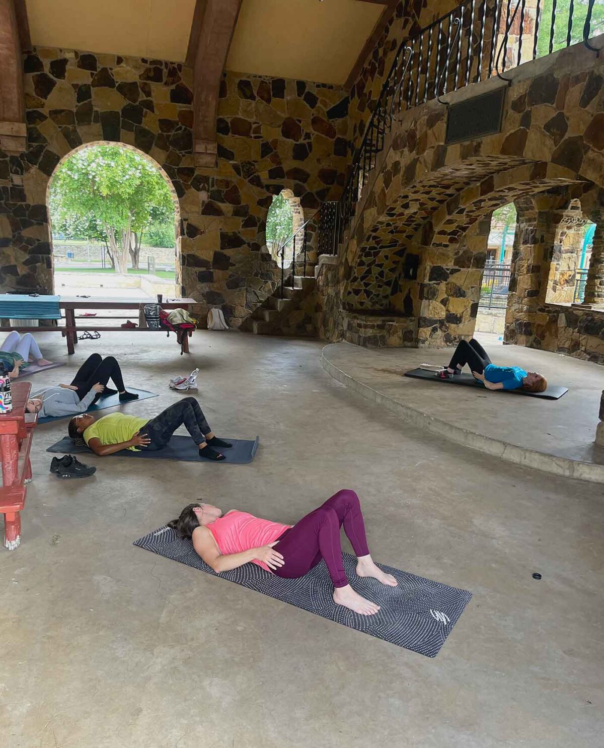 A group of people laying on yoga mats doing Pilates in Joske Pavilion