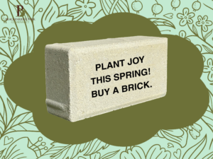 Inscribed brick that says "Plant joy this spring! Buy a brick"